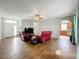 Open living room with red leather recliners, tile floors, and a view to the kitchen at 189 Perfect Dr, Daytona Beach, FL 32124