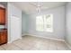 Well-lit room featuring tile floors, a ceiling fan, and a large window at 189 Perfect Dr, Daytona Beach, FL 32124