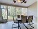 Bright screened porch with table and chairs, overlooking a wooded area at 189 Perfect Dr, Daytona Beach, FL 32124