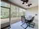 Screened porch with table, chairs, and wooded view at 189 Perfect Dr, Daytona Beach, FL 32124