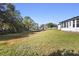 Large backyard with grassy lawn, mature trees, and a chain link fence at 1911 S Palomar Dr, Deltona, FL 32738