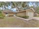 Tan single-story house with attached garage and mature landscaping at 2125 Queen Palm Dr, Edgewater, FL 32141