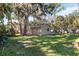 Tan house exterior with lush green backyard and trees at 2125 Queen Palm Dr, Edgewater, FL 32141