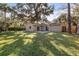 Tan house exterior with a spacious backyard and large trees at 2125 Queen Palm Dr, Edgewater, FL 32141