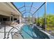 Screened-in pool with a waterfall feature and lush landscaping, perfect for outdoor relaxation and entertainment at 2815 Sienna View Ter, New Smyrna Beach, FL 32168