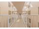 An indoor hallway with balconies and white railings that gives an airy and bright feel at 3 Oceans West Blvd # 4A5, Daytona Beach Shores, FL 32118