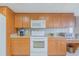 This kitchen features wood cabinets, granite countertops and white appliances at 3 Oceans West Blvd # 4A5, Daytona Beach Shores, FL 32118