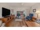 Comfortable living area with wood flooring, desk, TV, chair, and wood furniture at 3 Oceans West Blvd # 4A5, Daytona Beach Shores, FL 32118