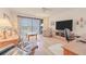 Relax in this comfy living room, with a ceiling fan, wood floors and sliding glass door at 3 Oceans West Blvd # 4A5, Daytona Beach Shores, FL 32118