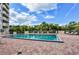 Community pool surrounded by greenery for privacy with clear skies at 3 Oceans West Blvd # 4A5, Daytona Beach Shores, FL 32118