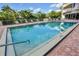 Community pool surrounded by landscaping with steps leading into the water at 3 Oceans West Blvd # 4A5, Daytona Beach Shores, FL 32118
