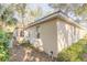 Tan house exterior with mature landscaping and large windows at 32543 Crystal Breeze Ln, Leesburg, FL 34788