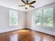 Bright bedroom with hardwood floors, ceiling fan and two windows at 345 N Clara Ave, Deland, FL 32720