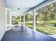 Large front porch with swing, white columns, and view of a tree-lined street at 345 N Clara Ave, Deland, FL 32720