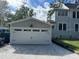 New two-car garage with white doors and paver driveway at 345 N Clara Ave, Deland, FL 32720