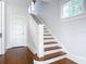 Classic wooden staircase with white railings in a bright hallway at 345 N Clara Ave, Deland, FL 32720