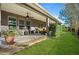 Landscaped backyard with a covered patio and grassy area at 3558 Nw 56Th Ave, Ocala, FL 34482