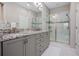 Elegant bathroom featuring granite countertops, double sinks, and a frameless shower enclosure at 3558 Nw 56Th Ave, Ocala, FL 34482