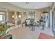 Cozy sunroom with tile floor, comfortable wicker seating and access to an outdoor patio through sliding glass doors at 376 Hampton Hills Ct, Debary, FL 32713