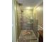 Walk-in shower with tile surround and glass shelves at 444 S Deerwood Ave, Orlando, FL 32825