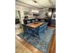 Dining area with a wood table, blue chairs, and a decorative rug at 444 S Deerwood Ave, Orlando, FL 32825