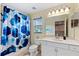 Clean bathroom with shower/tub combo, white vanity, and geometric shower curtain at 5423 Swordfern Ct, Port Orange, FL 32128