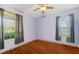 Simple bedroom with wood floors and two windows at 5423 Swordfern Ct, Port Orange, FL 32128