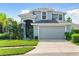 Two-story house with gray exterior, two-car garage, and well-maintained landscaping at 5423 Swordfern Ct, Port Orange, FL 32128