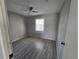 Well-lit bedroom with gray walls, wood-look floor, and ceiling fan at 610 Division St, Daytona Beach, FL 32114