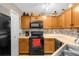 Galley kitchen with oak cabinets and modern appliances at 963 Helmsley Ct # 207, Lake Mary, FL 32746