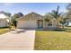 Tan one-story house with a two-car garage and palm trees at 981 Wilmington Dr, Deltona, FL 32725