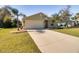 Tan one-story house with a two-car garage and palm trees at 981 Wilmington Dr, Deltona, FL 32725