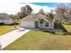 Inviting single-story home featuring a manicured lawn, youthful palm trees, and a two-car garage at 981 Wilmington Dr, Deltona, FL 32725