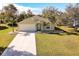 Charming single-story home with a well-manicured lawn, palm trees, and a freshly painted two-car garage door at 981 Wilmington Dr, Deltona, FL 32725