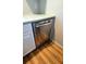 Stainless steel dishwasher in a galley kitchen with white cabinets at 11346 Circle Way, Leesburg, FL 34788