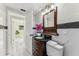 Updated bathroom features a vanity with a dark countertop, marble tile, and a large mirror at 118 N Sunland Dr, Sanford, FL 32773