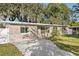 Newly renovated tan brick house with a white fence, driveway and landscaping at 118 N Sunland Dr, Sanford, FL 32773