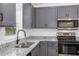 Bright kitchen showcasing gray cabinetry, granite countertops, and a stainless steel sink at 1205 2Nd St, Orange City, FL 32763