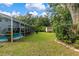 Large backyard with a pool and patio area, surrounded by trees at 163 Laurelwood Ln, Ormond Beach, FL 32174