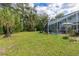 Large backyard with pool and patio, screened enclosure, lush landscaping at 163 Laurelwood Ln, Ormond Beach, FL 32174