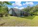 Backyard with a screened pool and patio, surrounded by trees at 163 Laurelwood Ln, Ormond Beach, FL 32174