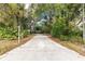 Long driveway leading to a beautiful home nestled amongst lush greenery at 163 Laurelwood Ln, Ormond Beach, FL 32174