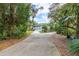 Driveway to house with mature trees and landscaping at 163 Laurelwood Ln, Ormond Beach, FL 32174