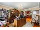 Home office with built-in shelving, a large desk, and a view of the kitchen at 163 Laurelwood Ln, Ormond Beach, FL 32174