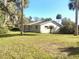 Back of the house showcasing a large grassy area and palm trees at 1848 Ridgewood St, Deland, FL 32720