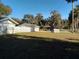Backyard with a large grassy area, a detached garage, and a fence at 1848 Ridgewood St, Deland, FL 32720