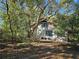 House partially obscured by large trees and surrounded by nature at 1937 N Spring Garden Ave, Deland, FL 32720