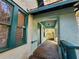 Covered front porch with green trim and access to the home at 1937 N Spring Garden Ave, Deland, FL 32720