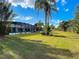 Expansive backyard featuring a screened-in pool, lush lawn, mature trees, and tropical landscaping at 2040 N Nemo Dr, Deltona, FL 32725