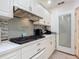 Close up on kitchen featuring white cabinets, modern appliances, and stylish tile backsplash at 2040 N Nemo Dr, Deltona, FL 32725